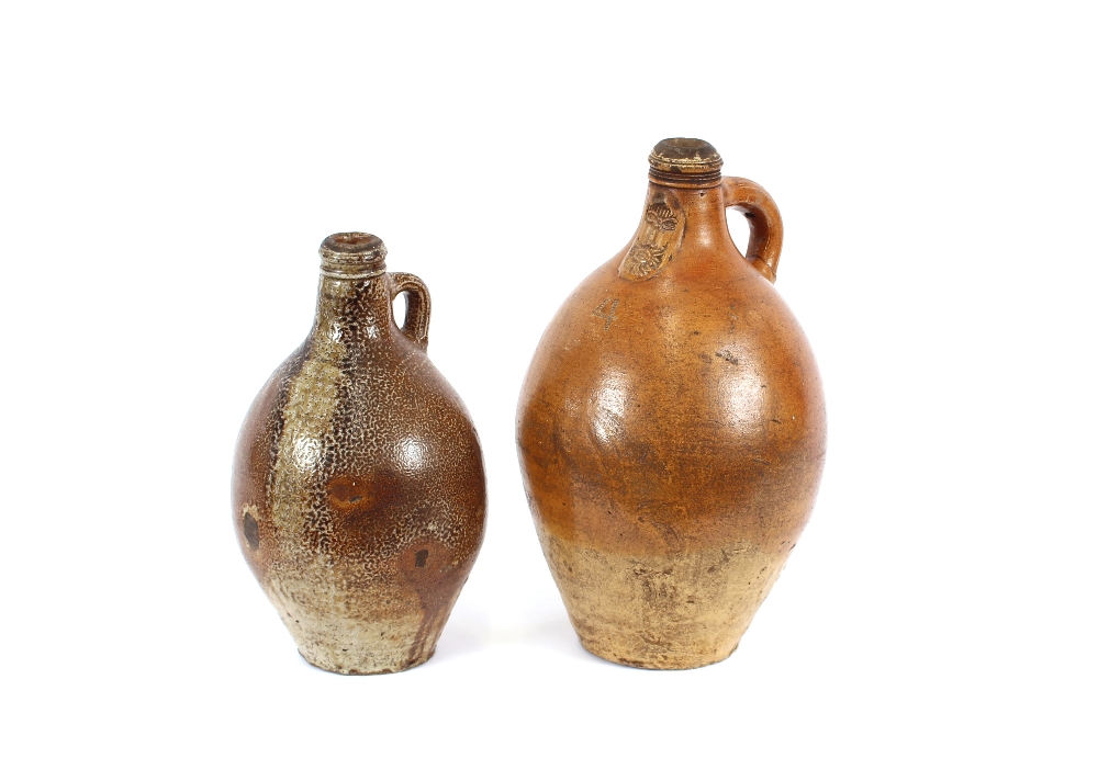 An Antique stoneware bellarmine, 44cm high; and a similar stoneware jug, 36cm high, (2)