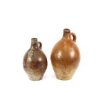 An Antique stoneware bellarmine, 44cm high; and a similar stoneware jug, 36cm high, (2)