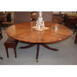 A large Georgian style circular mahogany dining table, raised on pedestal base and reeded legs,