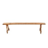 A pair of antique fruit wood long benches, raised on turned baluster supports united by