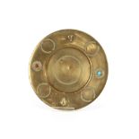 An Eastern circular brass dish, decorated with red and turquoise cabouchon stones and raised motifs,