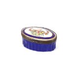 A small 18th Century blue ground Battersea enamel oval snuff box, decorated with flowers and