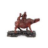 A 19th Century Chinese well carved group of boys riding a water Buffalo, standing on a carved wood