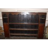 An 18th Century oak dresser rack, with boarded back, fitted shelves flanked by cupboards, 200cm