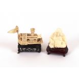 An early 20th Century ivory carving of a Chinese junk, on carved wooden stand, 6.5cm long; and an