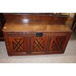 An Antique oak and inlaid three panelled coffer, the lid with iron hasp and lock above a foliate