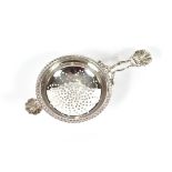 A silver tea strainer, having shell and gadroon decoration, London 1958