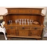 An oak Arts & Crafts sideboard, by Wylie & Lochhead, having raised back, three drawers and cupboards