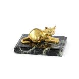 A small gilded bronze figure of a recumbent cat, on green and black marble base, signed G
