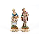 A pair of late 19th Century Meissen style figures, depicting maid and youth, raised on floral