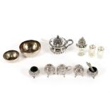 A five piece Eastern white metal cruet; three various silver cruet spoons; a silver baluster