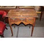 An 18th Century oak low boy, fitted three drawers above a shaped frieze on rounded tapering supports