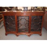 An early 20th Century mahogany dwarf breakfront bookcase, the adjustable shelves enclosed by three