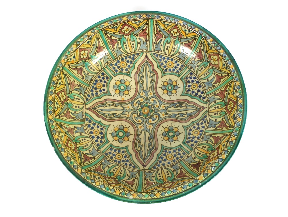 A large brightly coloured Iznic pottery bowl, having all over stylised decoration, 49.5cm dia.