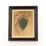 A Victorian shield shaped mirror, the surround decorated ferns contained in an ebonised frame
