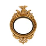 A large 19th Century gilt framed convex wall mirror, having eagle surmount, the circular plate