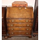 An oak bureau, of small proportions, having fitted interior above four long graduated drawers,