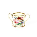 A large double handled porcelain mug, painted with floral decoration and script, heightened in gilt,