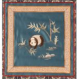 A Chinese silk and needlework panel, depicting Panda amongst bamboo shoots,  having stylised motif