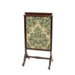 A Victorian mahogany pull up fire screen, having embroidered panels raised on scrolled supports