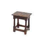 An Antique oak joint stool, the rectangular carved top raised on turned baluster supports united