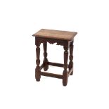An Antique oak joint stool, the rectangular moulded top raised above a shaped frieze, on turned