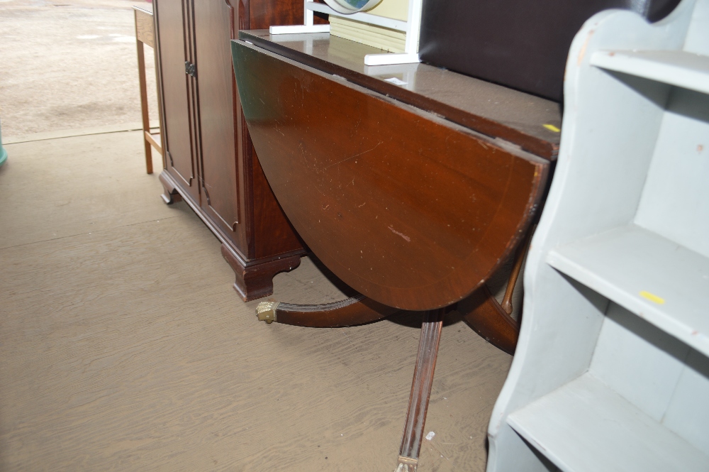 A reproduction mahogany drop leaf dining table; a