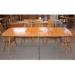 A light Ercol extending dining table, fitted two e
