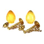 A pair of brass wall lights, complete with amber g