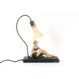 An Art Deco style lamp, in the form of a seated ma