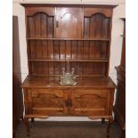 An oak Arts & Crafts dresser, the shelved and boar