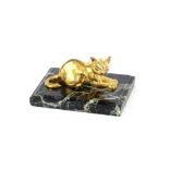 A small gilt bronze figure of a recumbent cat, on