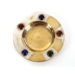 A small plated circular dish, decorated with cabou