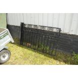 A wrought iron garden gate and posts