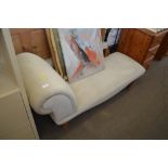 A grey upholstered chaise longe