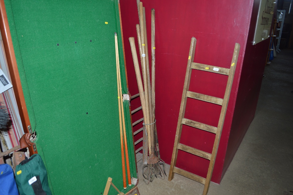 A bundle of long handle gardening tools