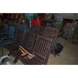 A hard wood garden table with five matching chairs