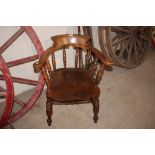 A late Victorian elm seated smoker bow elbow chair