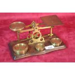 A set of brass postal scales and weights