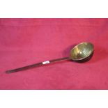 An antique brass and steel handled ladle