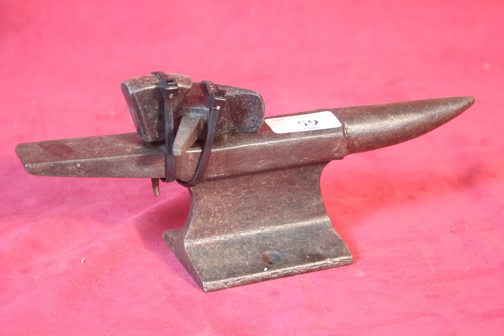 A miniature cast iron anvil and accessories, 26cm