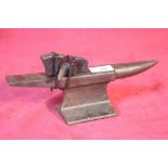 A miniature cast iron anvil and accessories, 26cm