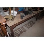 An antique pine kitchen table raised on square sup