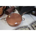 An antique copper saucepan and lid with iron handl