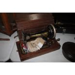 A Singer hand sewing machine in a wooden case with