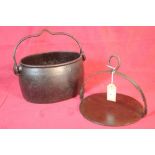 A cast iron oval swing handled cooking pot and an i