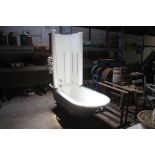 A 1920's canopy roll top bath, raised on ball and