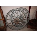 A pair of vintage wooden cart wheels with iron rim