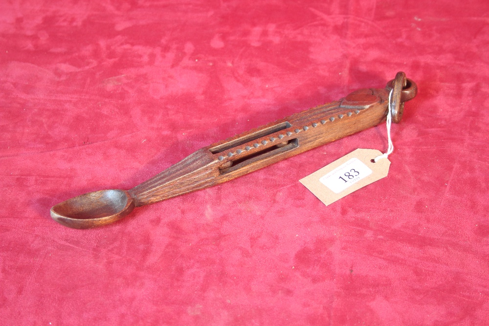 An antique carved oak love spoon, decorated with p