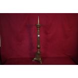 An antique brass pricket candlestick raised on Cor